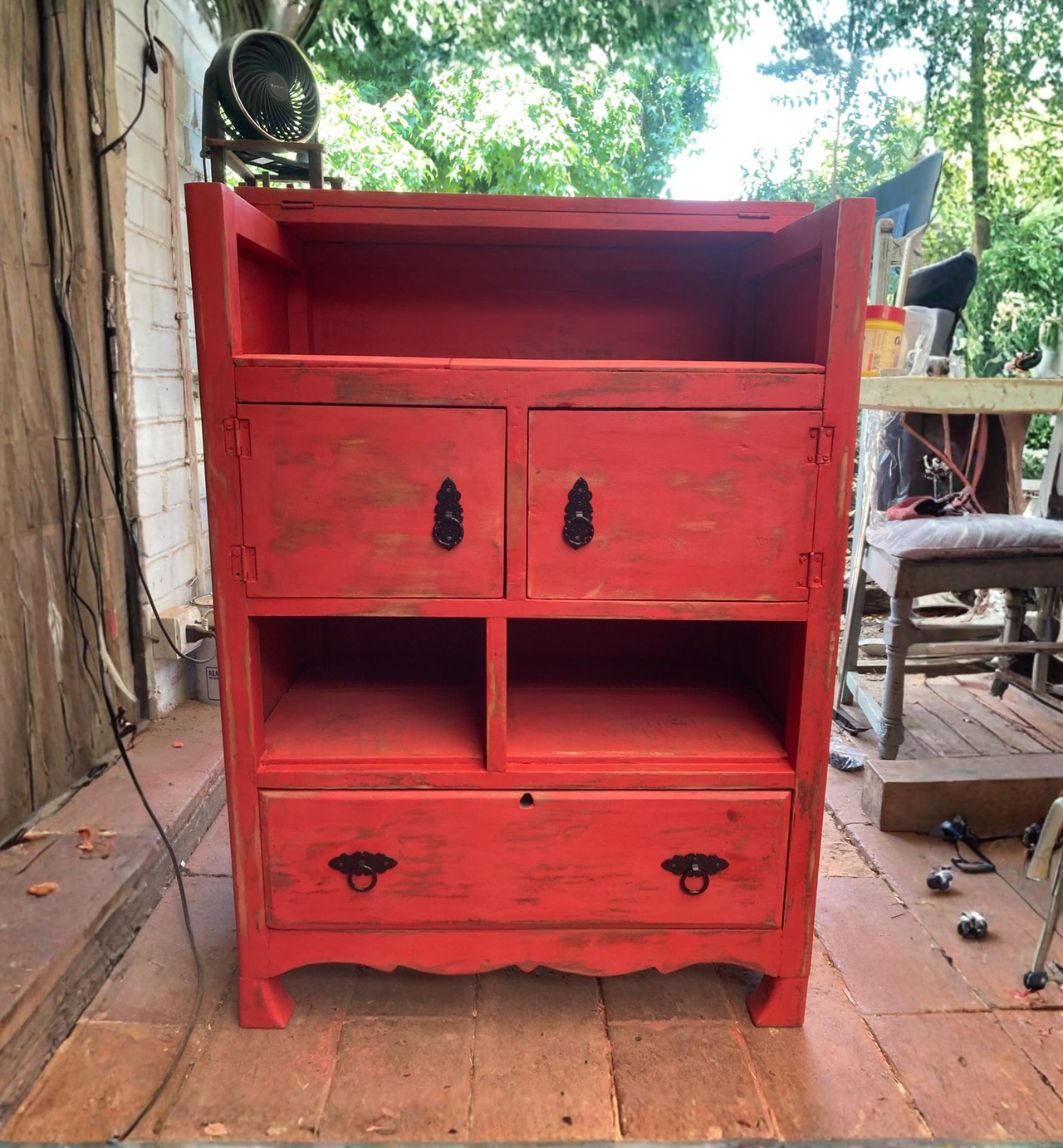 un mueble pintado de rojo especie envejecido